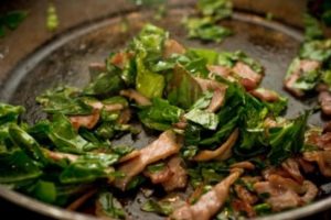 Frying the bacon and spring greens