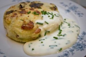 spring green and bacon potato cake with cheddar and chive sauce