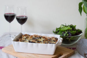 Layered Ragu and Aubergine Pasta Bake with salad and wine