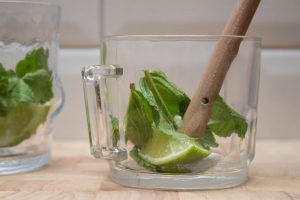 bashing the lime and mint together for mojitos