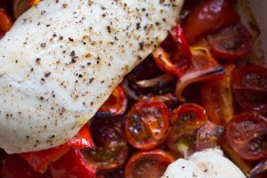 roasted chicken on top of tomatoes, peppers and chorizo